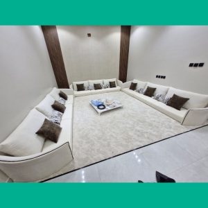 أريكة زاوية كريمية مع طاولة خشبية